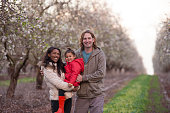 Happy family on almond field in springtime.