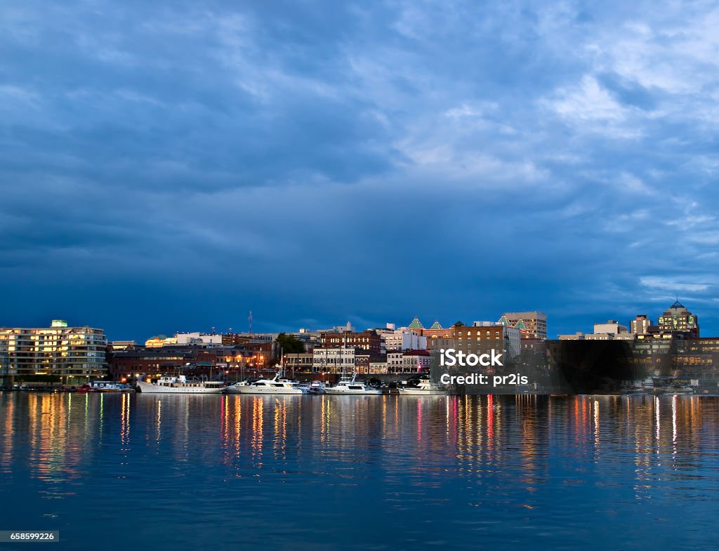 Street lights reflect in water at Inner Harbor, Victoria, BC Canada Stock Photo