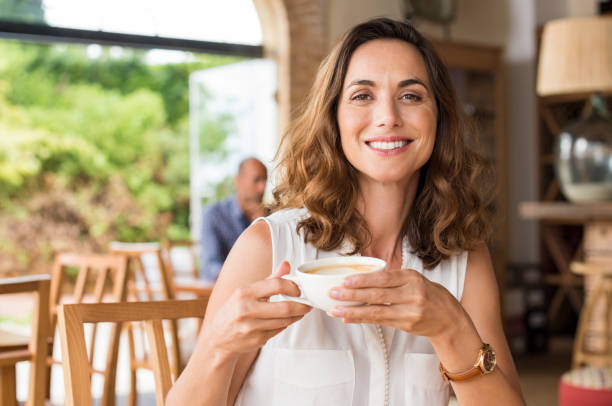 mature woman at cafeteria - mid aged woman imagens e fotografias de stock