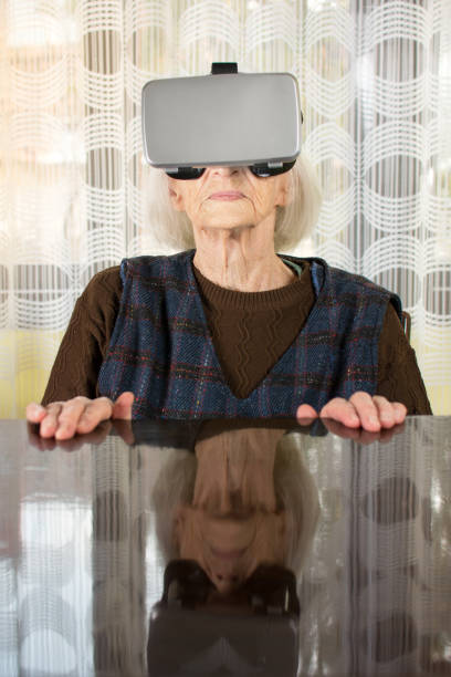 istock Grandma trying to use VR goggles 658605360