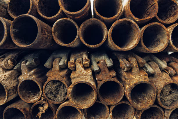 istock Old rusty used scaffolding steel pipes stacked 658606312
