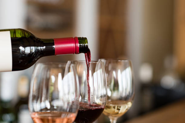 gieten van wijn in glazen - drinking wine stockfoto's en -beelden