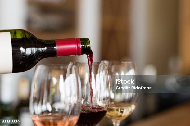 Pouring Wine In Glasses Stock Photo - Download Image Now - Wine Tasting, Wine, Wine Bottle