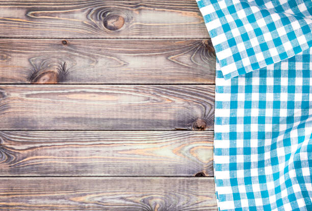 White old wooden table with blue checkered tablecloth, top view with copy space