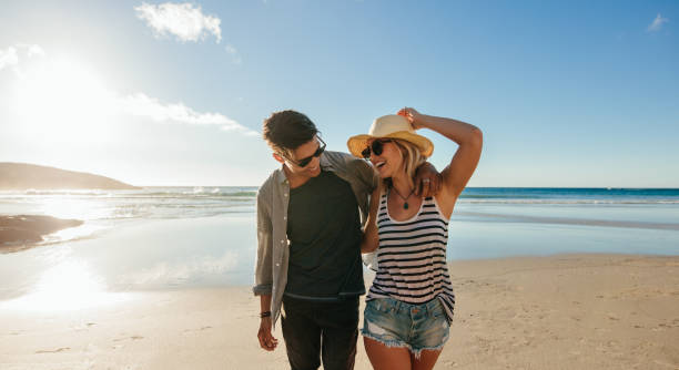 istock Couple walking on seashore and laughing 658621908