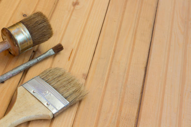 istock Three paint brushes on the wooden floor 658622060