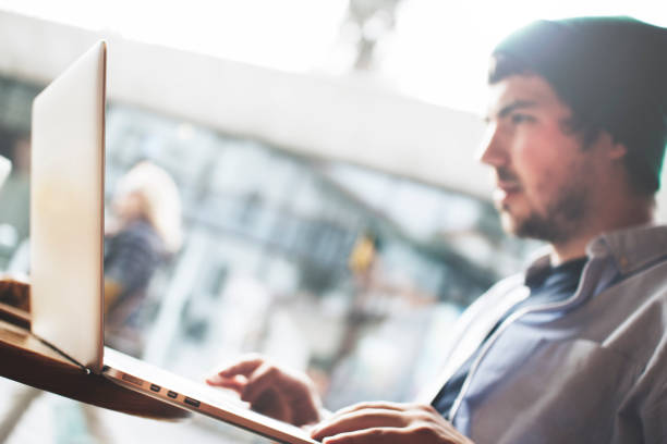 istock Concentrated blogger is sitting in a cafe and working for a laptop 658625778