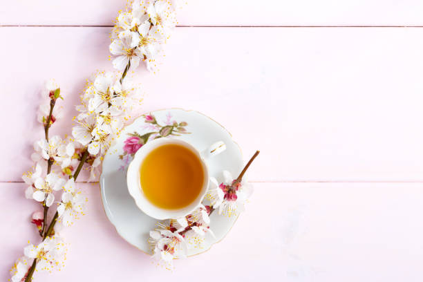 istock Cup of  tea and spring  flowers  on  light pink wooden table. 658629114
