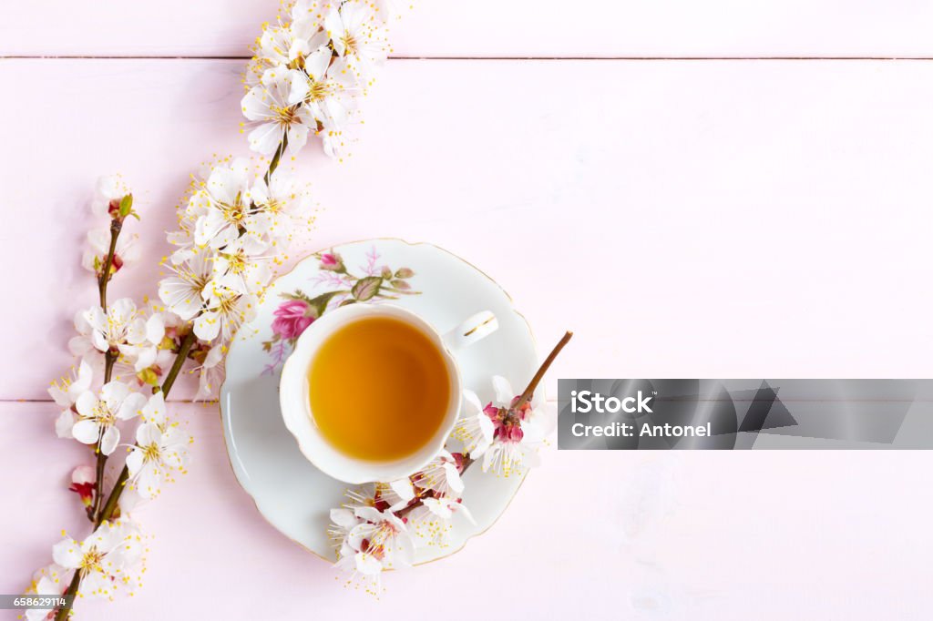 Cup of  tea and spring  flowers  on  light pink wooden table. Flower Stock Photo