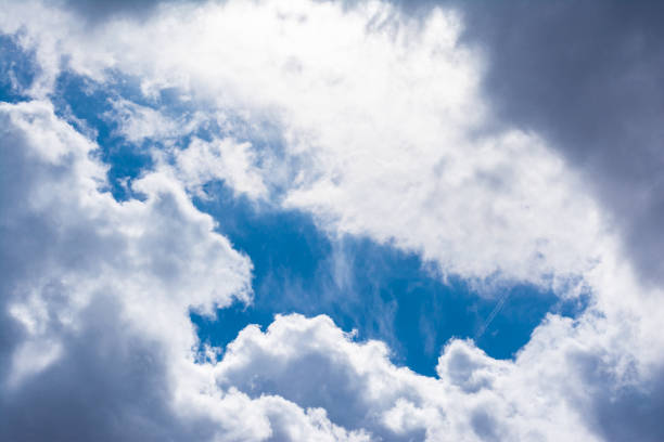 istock White Clouds Blue Sky Fluffy Sun Flare Airplane Trail  Sunny Daytime Texture Background 658629170