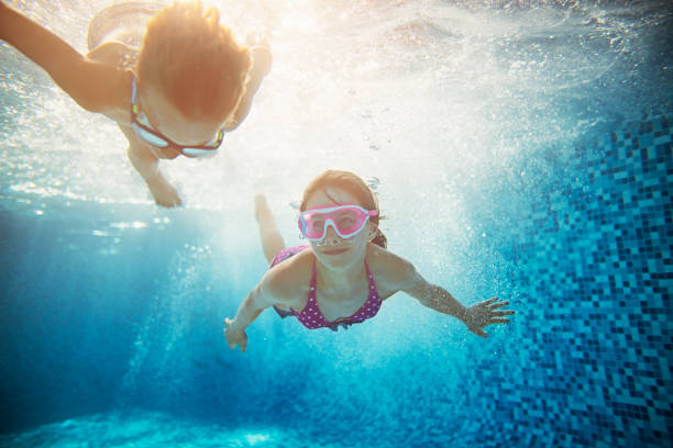 istock Brother and sister swimming underwater 658638484