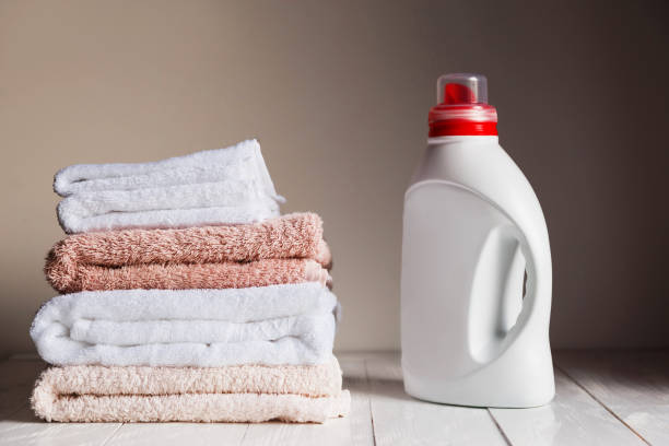 istock Stack of several coloured and white towels and bottle with cosmetic product 658639194