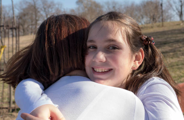 istock Mother and Daughter hugging in park during the sunny spring day 658640054
