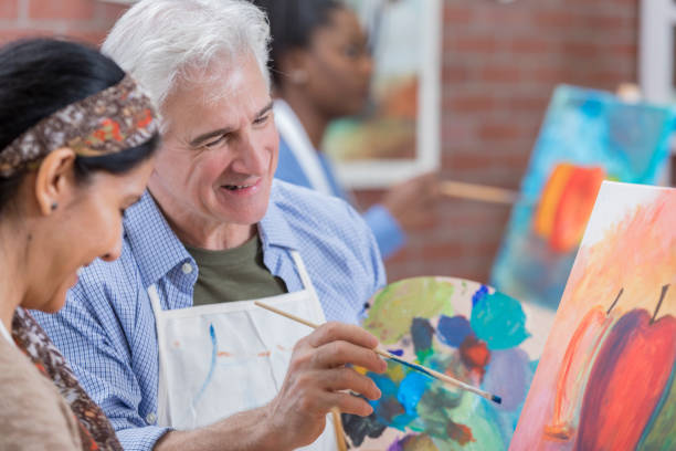 年配の��男性は、美術の授業を楽しんでいます - easel adult art creativity ストックフォトと画像