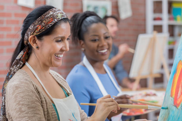 istock Diverse female friends paint together during art class 658645980