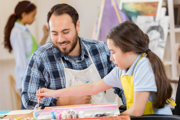 istock Art teacher helps preteen student 658647110