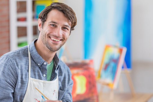 Smiling mid adult Caucasian man in his art studio.