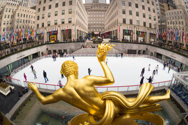 Golden Prometheus statue and Rockefeller Center ice skate rink, Manhattan, New York City, USA. New York City, USA - March. 2015: Golden Prometheus statue and Rockefeller Center and tourists and ice skaters visiting Rockefeller Center ice skate rink on 24th of March,2015. rockefeller ice rink stock pictures, royalty-free photos & images