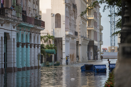 View of Paseo del Prado that was flooded, the main street of Old Habana. Tourist and local people on the background and walk in the water.