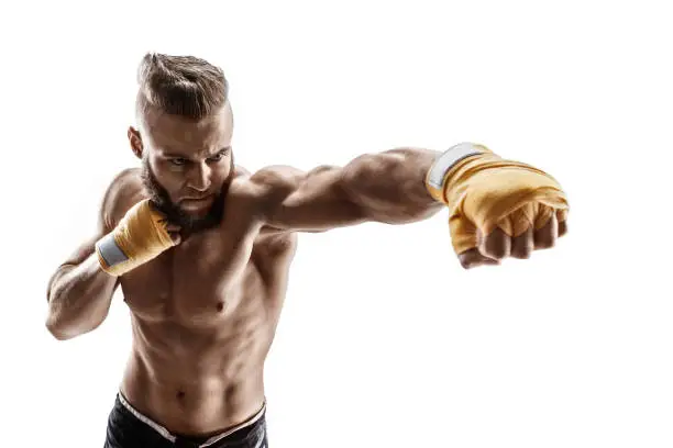 Sporty man throwing a fierce and powerful punch. Photo of muscular man isolated on white background. Strength and motivation