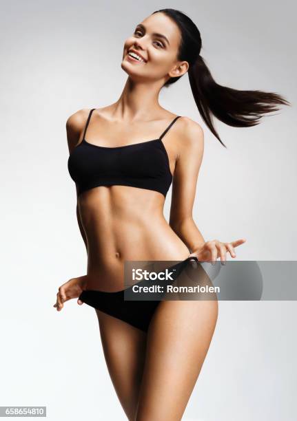 Laughing Sexy Girl In Black Bikini Posing On Grey Background Stock Photo - Download Image Now