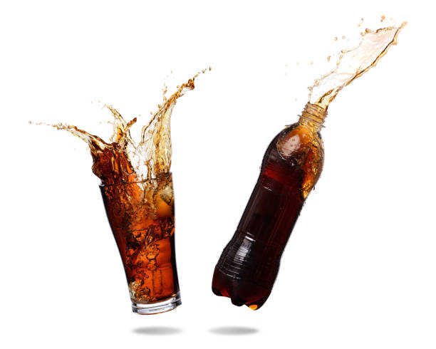 Cola splashing Couple cola splashing out of glass and bottle., Isolated white background. wet bottle stock pictures, royalty-free photos & images