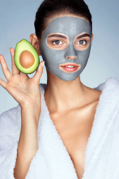 istock Attractive woman holding half an avocado in hand. 658654928