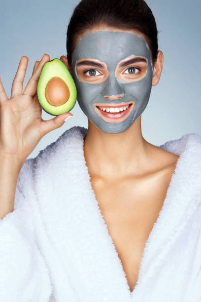 istock Smiling woman holding half an avocado in hand 658654938
