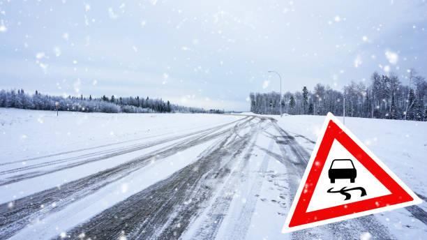 istock winter driving with road sign - slippery road 658657718