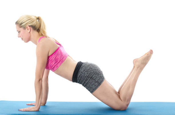 istock Young woman doing full body yoga exercise  on blue mat 658660974