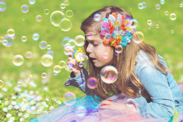 istock Little girl having fun, blowing soap bubbles 658666028