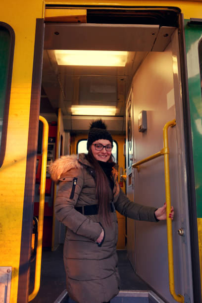 Young woman enters a train car Young woman gets in - 
 mütze stock pictures, royalty-free photos & images
