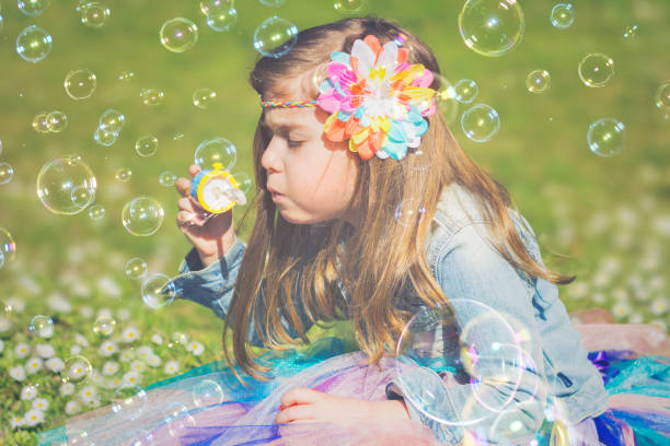 istock Little girl having fun, blowing soap bubbles 658668638