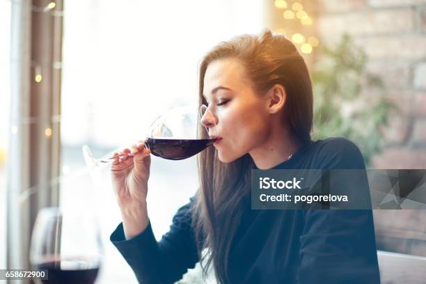 Beautiful Young Woman Drinking Red Wine With Friends In Cafe Portrait With Wine Glass Near Window Vocation Holidays Evening Concept Stock Photo - Download Image Now