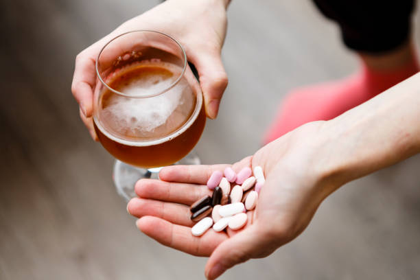 adicto, mujer con pastillas y cerveza en las manos. - narcotic medicine pill insomnia fotografías e imágenes de stock