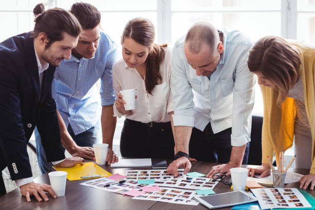 istock Photo editors looking at photos on table 658680322