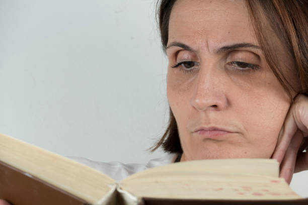 istock Young woman reading a book on a couch 658689146