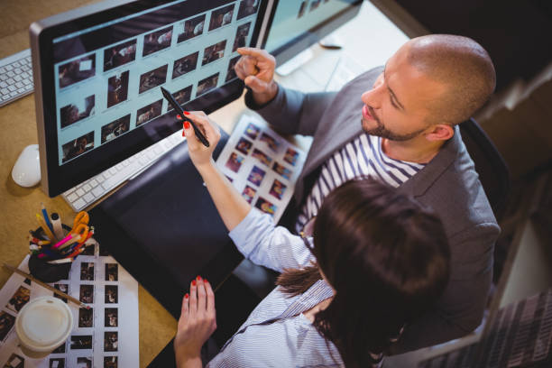istock Coworkers discussing over computer at desk 658709432