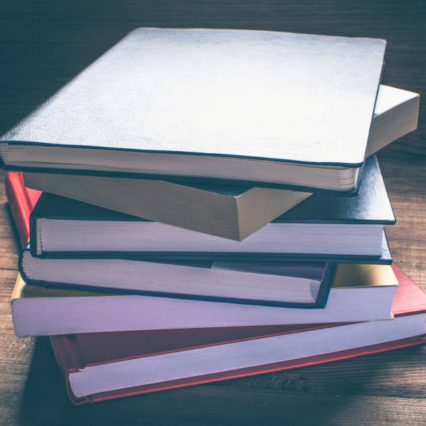 istock Research in library. Stack of books on the wooden bookshelf 658735236