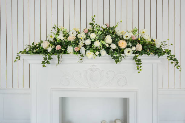 istock Bouquet of flowers over white fireplace in classic interior 658743646