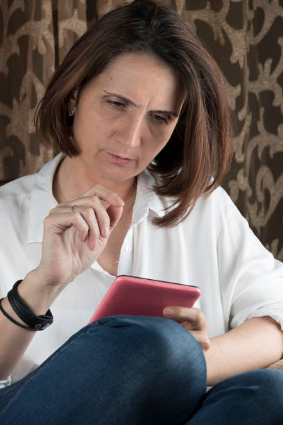 istock Young woman using tablet and sitting in a chair 658787092