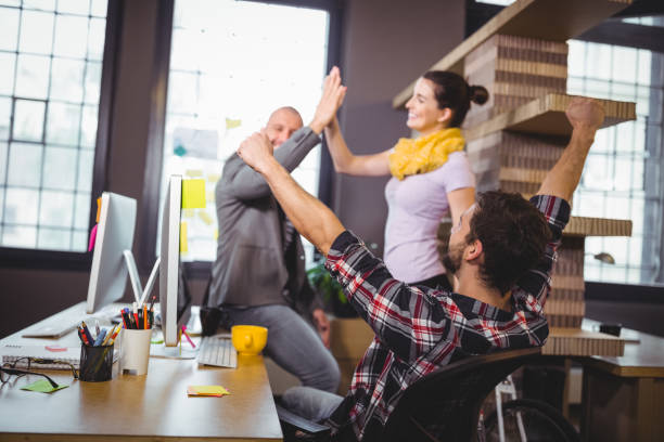 istock Business people cheering at computer desk 658789460