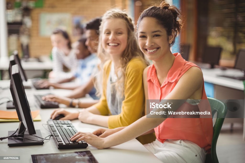 Portrait of smiling students studying in computer classroom Portrait of smiling students studying in computer classroom at school Teenager Stock Photo