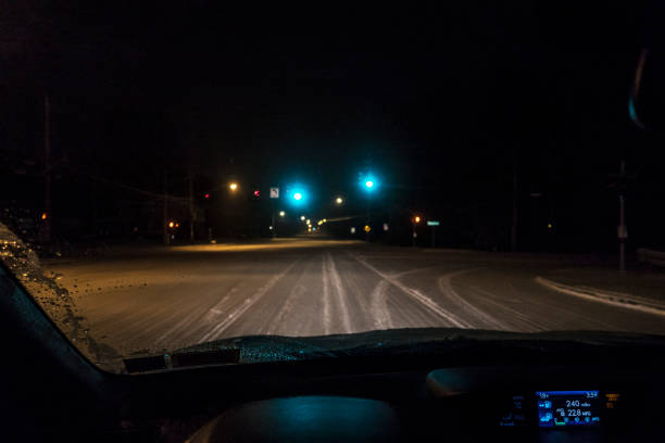istock Night Car Driver POV Approaching Winter Road Intersection Green Lights 658817374