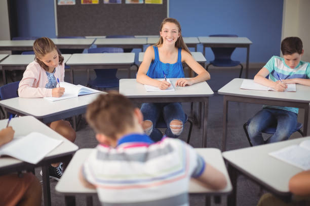 istock Schoolgirl sitting at desk in classroom 658821940