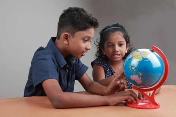 istock Boy and girl with a globe 658830476