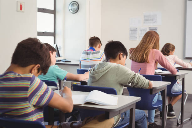 istock Attentive school kids doing homework in classroom 658835356