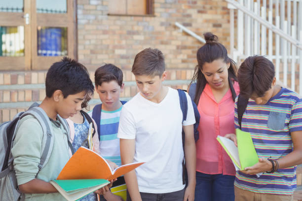 istock School kids discussing over text book in campus 658836066