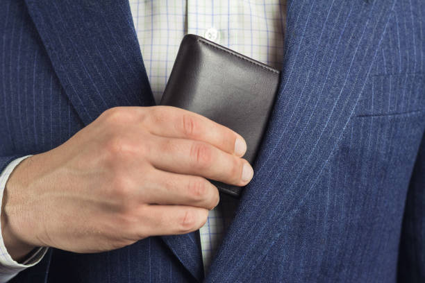 istock Business man pulls out or put his leather wallet into jacket pocket. 658846140
