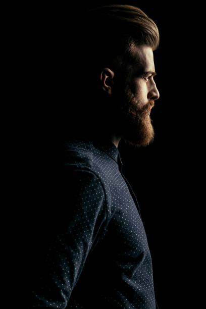 istock Side view of serious handsome bearded man looking away on black 658846216